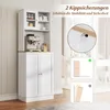 A white kitchen cabinet with a glass-doored upper section and two solid doors below, featuring an espresso machine on its countertop. The image also includes diagrams illustrating anti-tip safety features. Podgląd zdjęcia produktu
