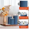 Three blue LED candles of varying sizes are displayed on a wooden surface, with a vase of flowers and foliage in the background. The image also includes three inset panels highlighting product features. Voir les images du produit