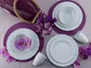 A table setting with white porcelain dishes, purple placemats, and purple flowers. Náhľad obrázku produktu