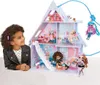 A young girl looks at a dollhouse with dolls. Produktbild-Vorschau
