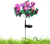 A solar-powered decorative flower light with pink and purple flowers and green leaves, planted in grass. Náhled obrázku produktu