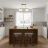 A modern kitchen with white cabinets, a wooden island with bar stools, and a large window overlooking a snowy landscape. Náhľad obrázku produktu