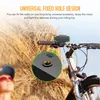 A person is looking up at a bicycle with a radio attached to the handlebars, set against a background of dry grass. Podgląd zdjęcia produktu