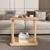 A C-shaped side table with books and donuts on it, placed in front of a sofa. Náhled obrázku produktu