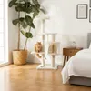 A cat tree is placed in a bedroom next to a large potted plant and a bed. Podgląd zdjęcia produktu
