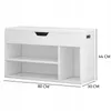 A white shoe cabinet with a padded top, featuring open shelving and a drawer-like front panel. Dimensions are indicated with text. Produktbild-Vorschau