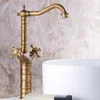 A close-up shot of a vintage-style brass faucet with a curved spout, positioned next to a white sink. The background is a textured, marbled wall. Produktbild-Vorschau