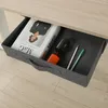 A drawer of a desk is open, showing office supplies. Voir les images du produit