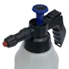 Close-up view of the top part of a white and black pump sprayer with a blue trigger and red nozzle tip. Produktbild-Vorschau