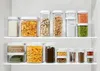 A pantry shelf filled with various clear plastic food storage containers. Voir les images du produit