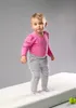 A baby standing on a white surface. Anteprima dell’immagine prodotto