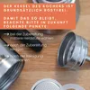 Close-up of parts of a stainless steel espresso maker on a wooden surface, with instructional text overlay. Produktbild-Vorschau