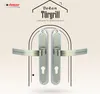 A pair of silver door handles are displayed against a light beige background with decorative geometric patterns and a stylized house outline. Produktbild-Vorschau