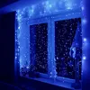 A window decorated with blue string lights, a gnome, and a small Christmas tree. Náhled obrázku produktu