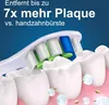 Close-up of a toothbrush head cleaning teeth, with text overlay. Voir les images du produit