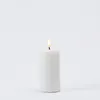 A white LED candle with a lit flame is centered against a plain white background. Podgląd zdjęcia produktu