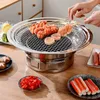 A close-up shot of a BBQ grill with food being cooked on it, set on a wooden table with various side dishes. Produktbild-Vorschau