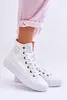 A person's legs wearing pink pants and white high-top sneakers. Produktbild-Vorschau