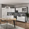 A modern kitchen with white high-gloss cabinets and a wooden dining table. Produktbild-Vorschau