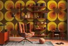 A retro-themed living room with a patterned wallpaper, a chair, and a bookshelf. Produktbild-Vorschau