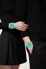 Two people wearing black clothing, each wearing a green watch. Produktbild-Vorschau