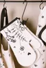 A close-up of oven mitts and an apron hanging on hooks. Anteprima dell’immagine prodotto