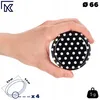 A hand holding a black lid with white polka dots. Produktbild-Vorschau