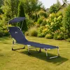 A navy blue folding lounge chair with a sunshade is set up on a green lawn in a garden setting. Náhled obrázku produktu
