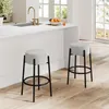 A modern kitchen with a white countertop, sink, and faucet, featuring two gray upholstered bar stools with black metal frames. Podgląd zdjęcia produktu