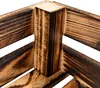 A close-up view of the corner of a wooden crate, showing the grain and burnt wood texture. Produktbild-Vorschau