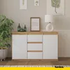 A modern sideboard with white doors and drawers, set against a neutral wall with decorative items and a plant. Voir les images du produit