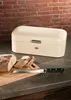 A cream-colored breadbox sits on a countertop next to a loaf of bread and a bread knife. Náhled obrázku produktu