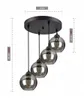 A black pendant light fixture with four smoked glass globes hanging from a circular ceiling plate. Produktbild-Vorschau