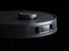 A close-up, studio shot of a black robot vacuum cleaner against a black background. Produktbild-Vorschau
