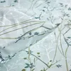 A close-up view of a pillow and bedding with a floral pattern. Produktbild-Vorschau