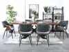 A dining room scene with a wooden table and chairs, a rug, a plant, and shelves with decor. Náhled obrázku produktu