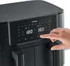 A hand is shown pressing a button on the digital display of a black air fryer. Produktbild-Vorschau