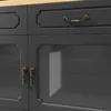 A close-up view of a dark gray cabinet with brass hardware and a wooden countertop. Produktbild-Vorschau