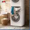 A stacked washing machine and dryer with a drawer open, containing laundry, in a laundry room setting. Voir les images du produit