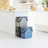 Three stackable trash bins are placed next to a white kitchen cabinet. Produktbild-Vorschau