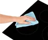 A hand is cleaning a black glass ceramic stovetop with a blue microfiber cloth. Náhľad obrázku produktu