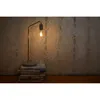 A desk lamp with a visible bulb sits on a stack of books against a textured wall. Produktbild-Vorschau