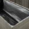 Close-up view inside a grey wicker-style garden storage box, showing a black liner and a silver liner. Voir les images du produit
