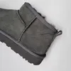 A close-up view of a grey Ugg boot. Voir les images du produit