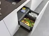 A kitchen drawer with a built-in waste sorting system, containing food scraps and crumpled paper. Produktbild-Vorschau