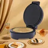 A waffle maker with a waffle inside, along with waffle cones and pastries, set against a backdrop of golden drapery. Náhled obrázku produktu