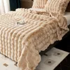 A close-up view of a plush blanket on a bed, with a cup and saucer on top. Náhled obrázku produktu