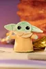A plush toy of The Child from Star Wars is displayed on a surface with a blurred background. Podgląd zdjęcia produktu
