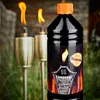 A bottle of lamp oil is shown in the foreground with two lit tiki torches in the background. Produktbild-Vorschau