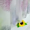 A close-up of sheer curtains with a firework pattern and a sunflower. Produktbild-Vorschau